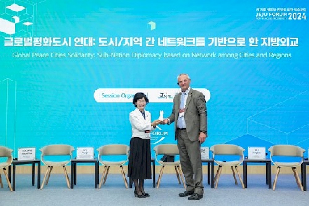 Phillippe Hansch presents Vice Governor Kim Ae-Sook with a miniature version of the PAPERBOMB at the JEJU FORUM